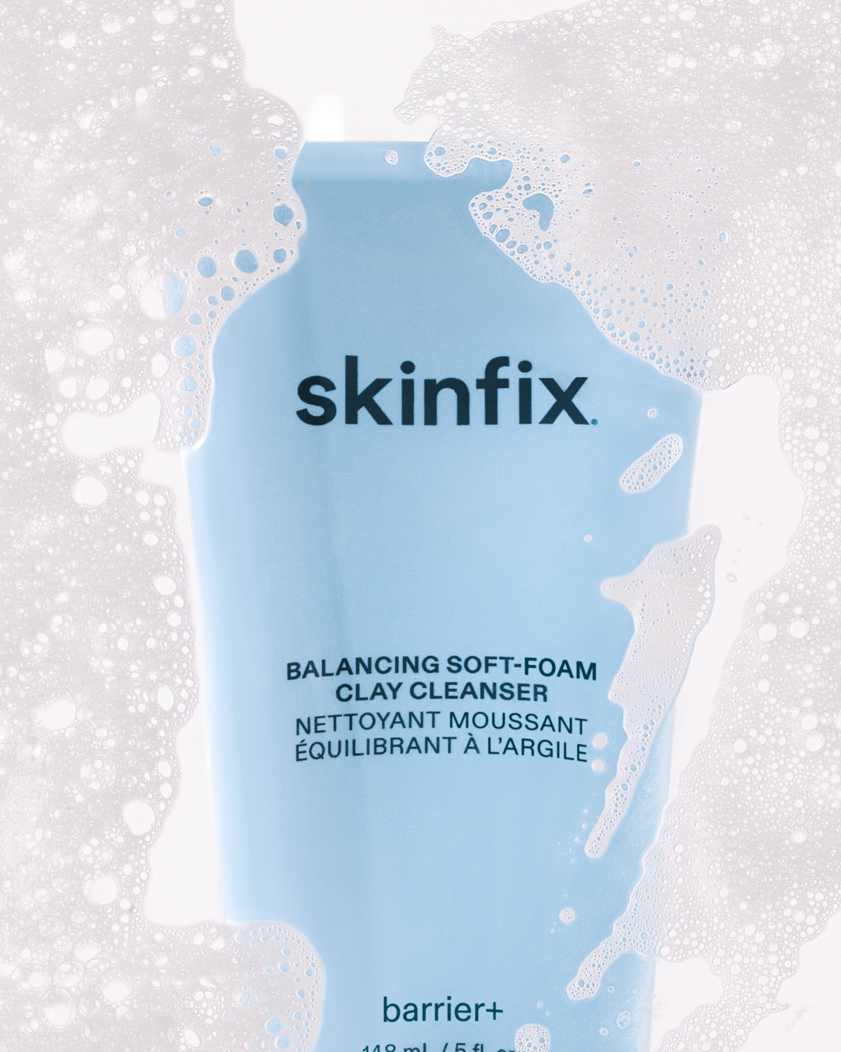 Skinfix Balancing Soft-Foam Clay Cleanser tube surrounded by soft foam and bubbles.