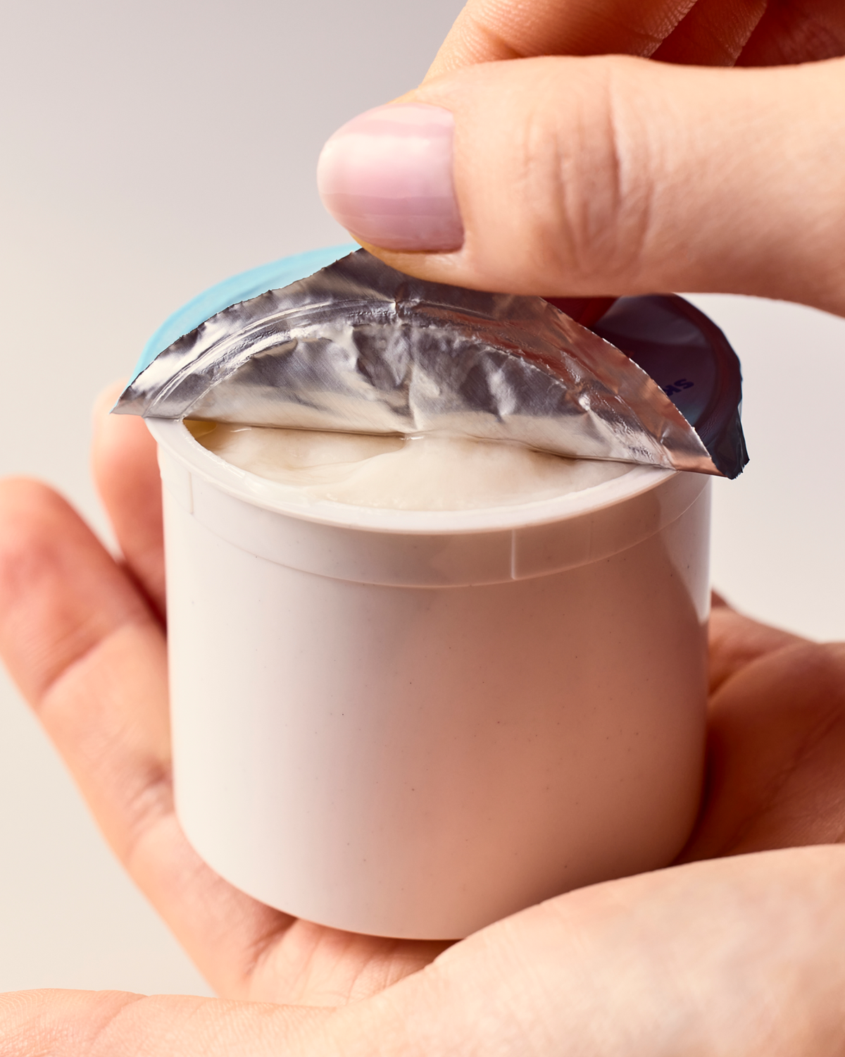 Hands holding Skinfix moisturizer refill removing foil covering