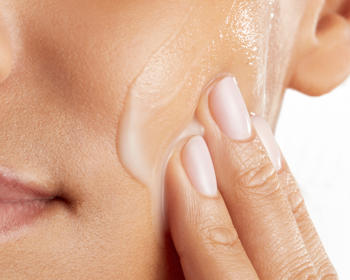 A person applying Skinfix Triple Lipid-Hyaluronate Serum to their cheek and jawline.